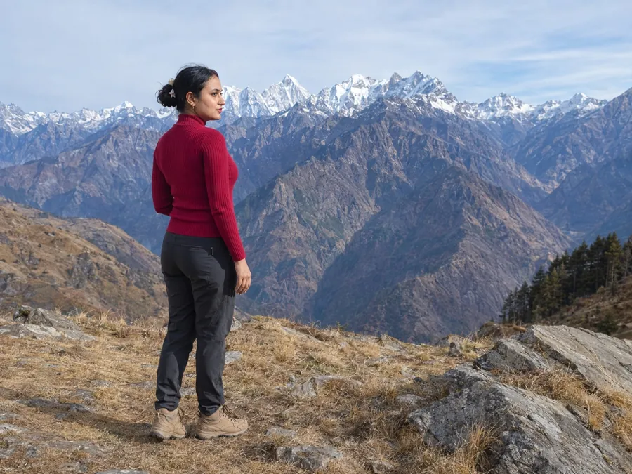 Vandana on a dry ridge looking across at the snow-capped Himalayan range, October 2024